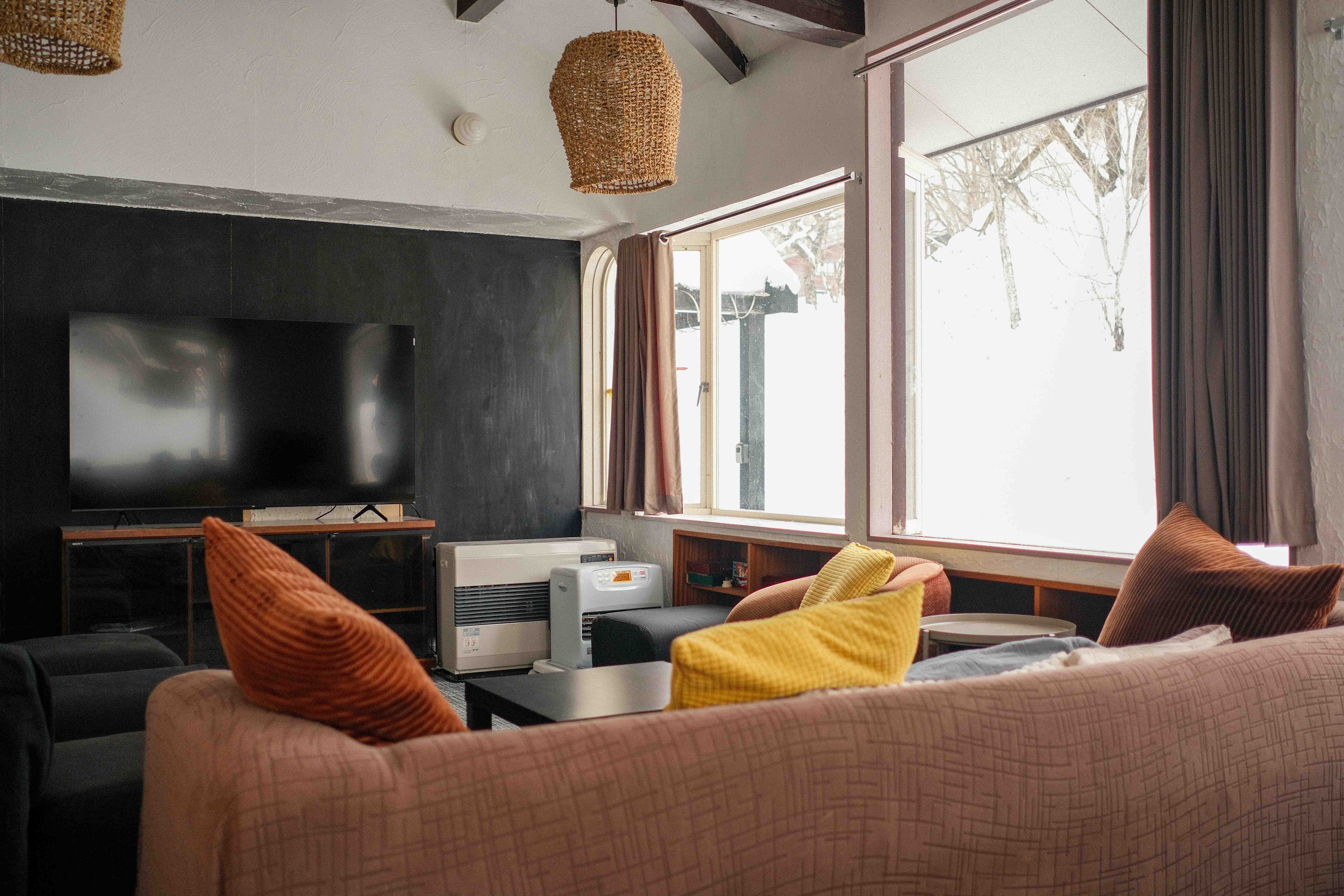 Living room with dark accent wall and woven pendants