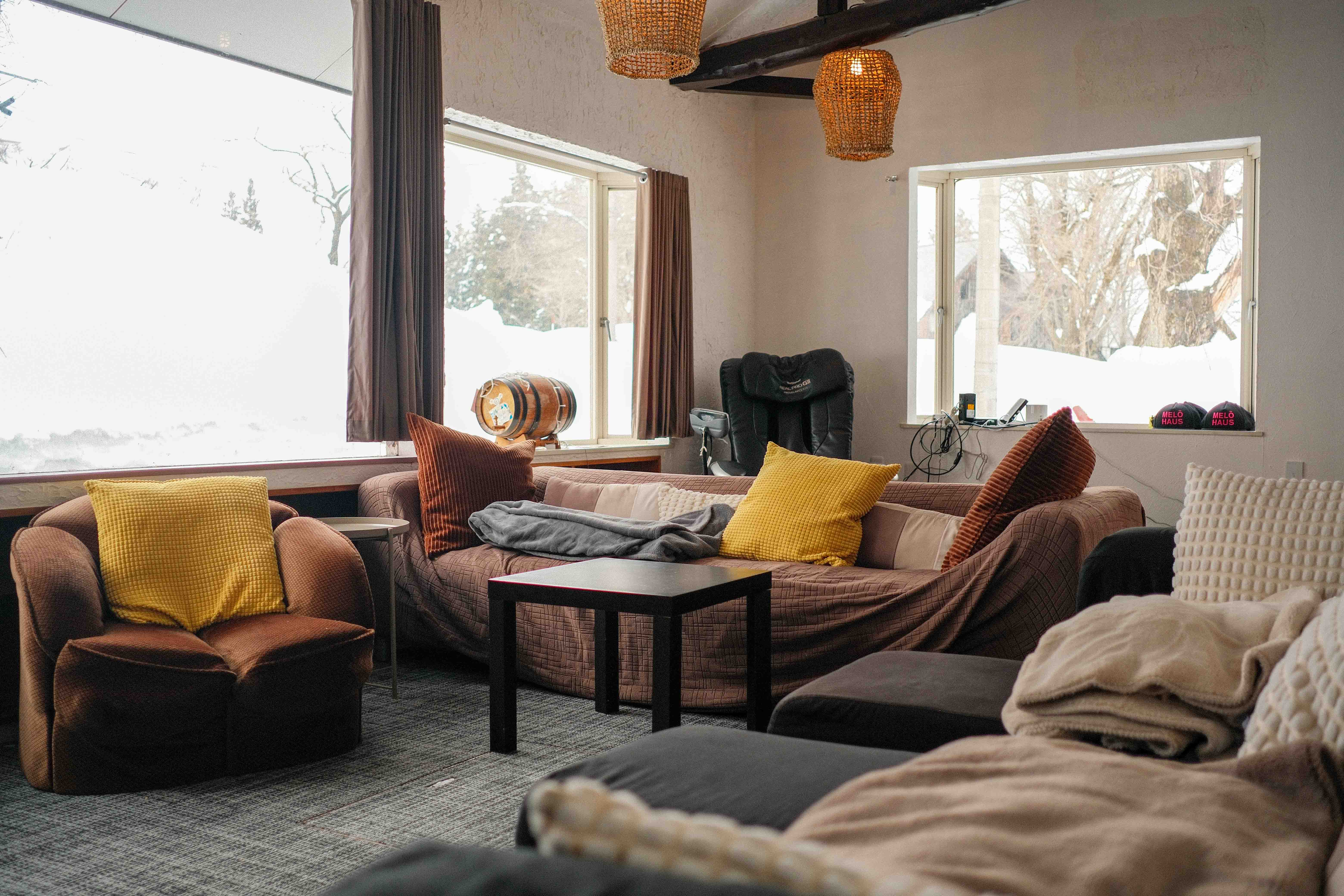 Melo Haus lounge with warm textiles and snow outside the windows